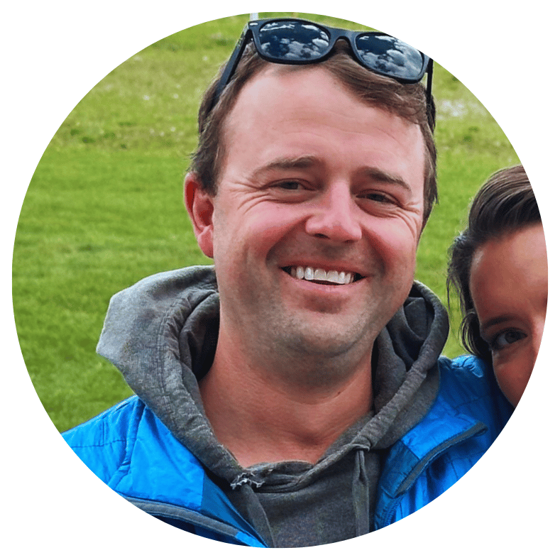 A professional leader in a blue jacket and grey hooded sweatshirt, embodying intentional growth and clear vision.