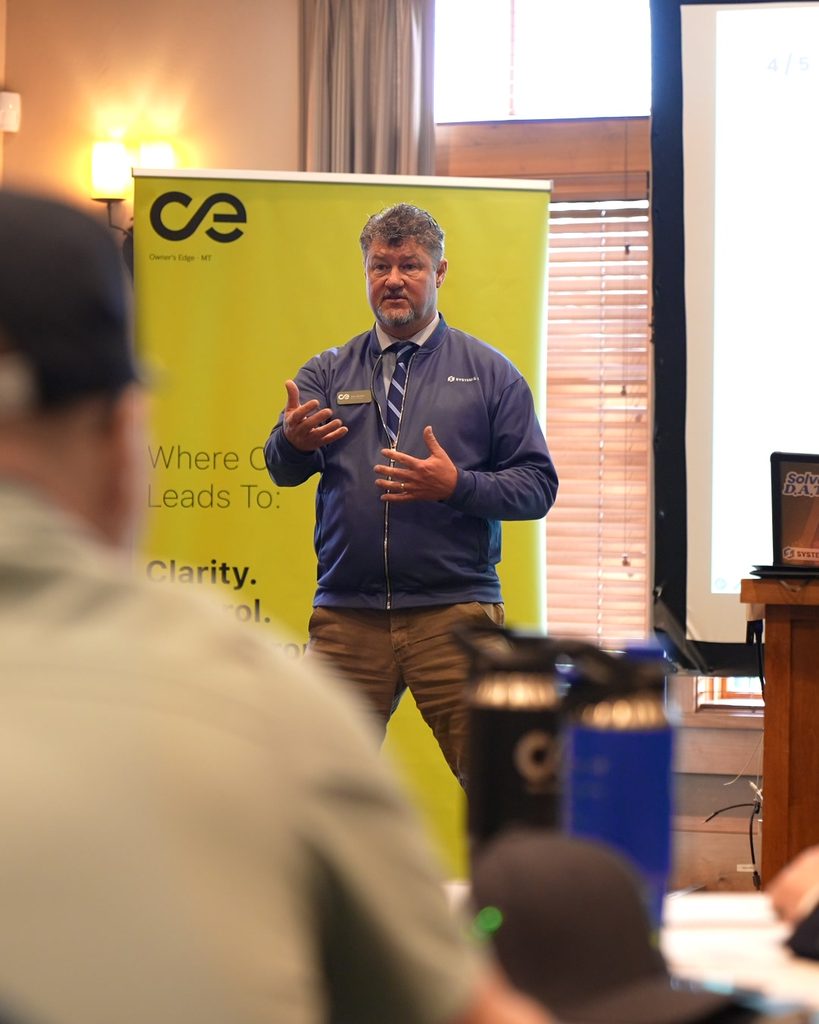 A speaker presents on leadership and sustainable growth at a professional business workshop.