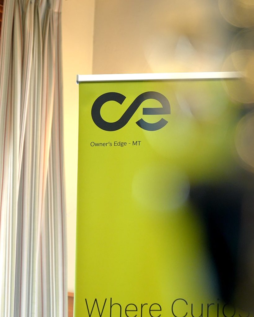 Lime green standing banner displaying the Owners Edge - MT logo, representing professional leadership and alignment.