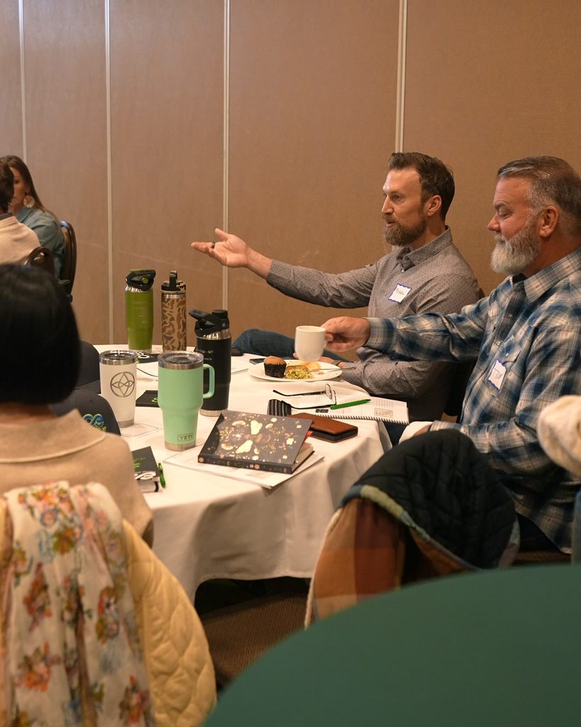 A leader gestures during a strategy meeting, fostering team alignment and intentional growth.