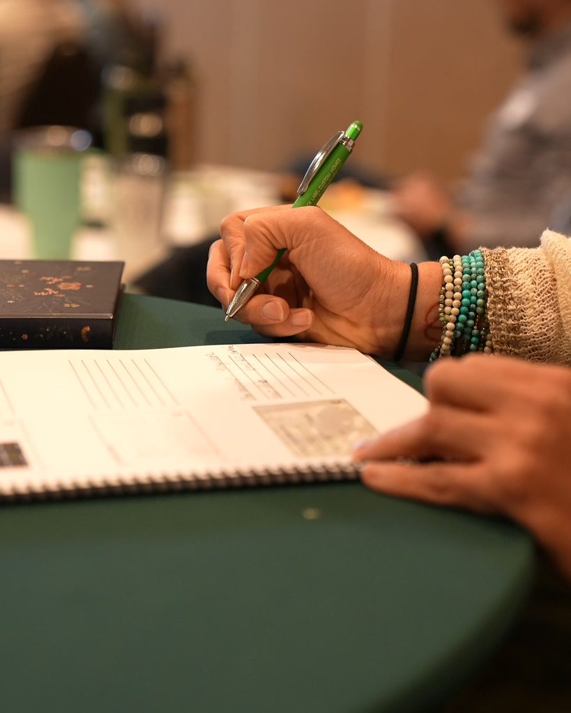 A professional hand writing in a notebook, symbolizing the systems thinking and intentional planning behind scaling growth.