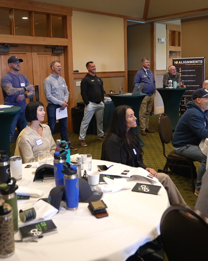 Professionals at a leadership workshop focused on sustainable growth and systems thinking, featuring the 10 Alignments.