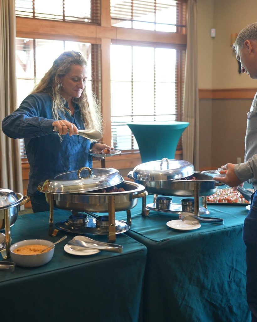 A woman serves herself at a buffet, representing the intentional systems and collaboration needed for sustainable growth.