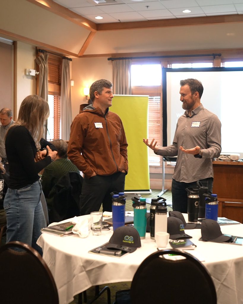 Three colleagues align on strategy and systems thinking in a conference room to drive sustainable business growth.