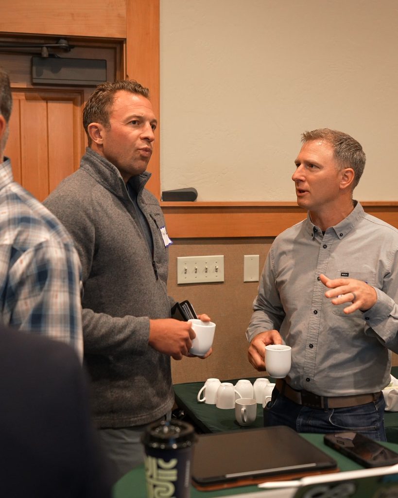 Two professionals discuss leadership and alignment over coffee, fostering a culture of sustainable growth.