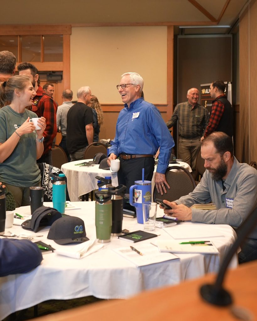 A man in a blue shirt fosters team alignment and professional connection during a networking event.