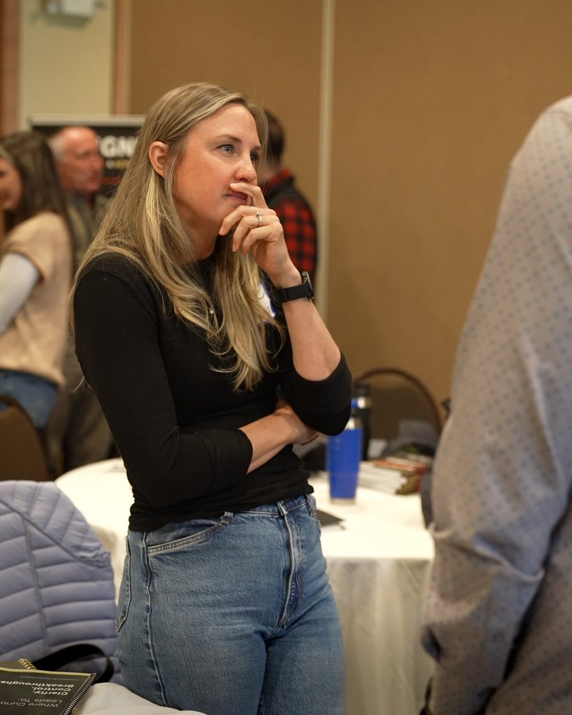 A professional leader in a black shirt listens intently, embodying the focus required for alignment and sustainable growth.