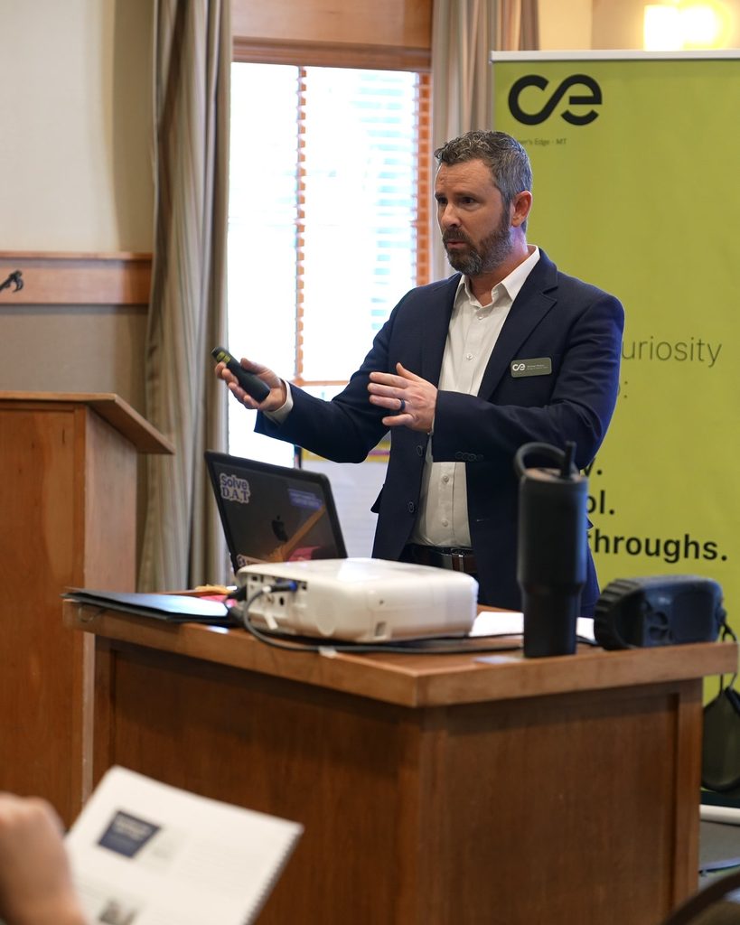 A business leader presents to an audience, driving alignment and sustainable growth from the podium.