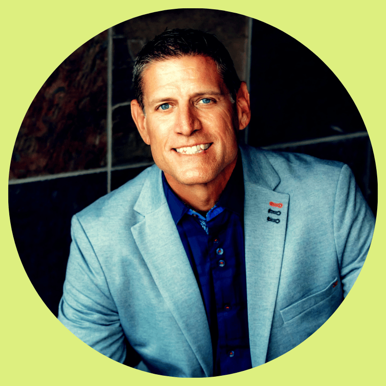 A smiling executive in a blue shirt and blazer, embodying professional leadership and intentional growth.